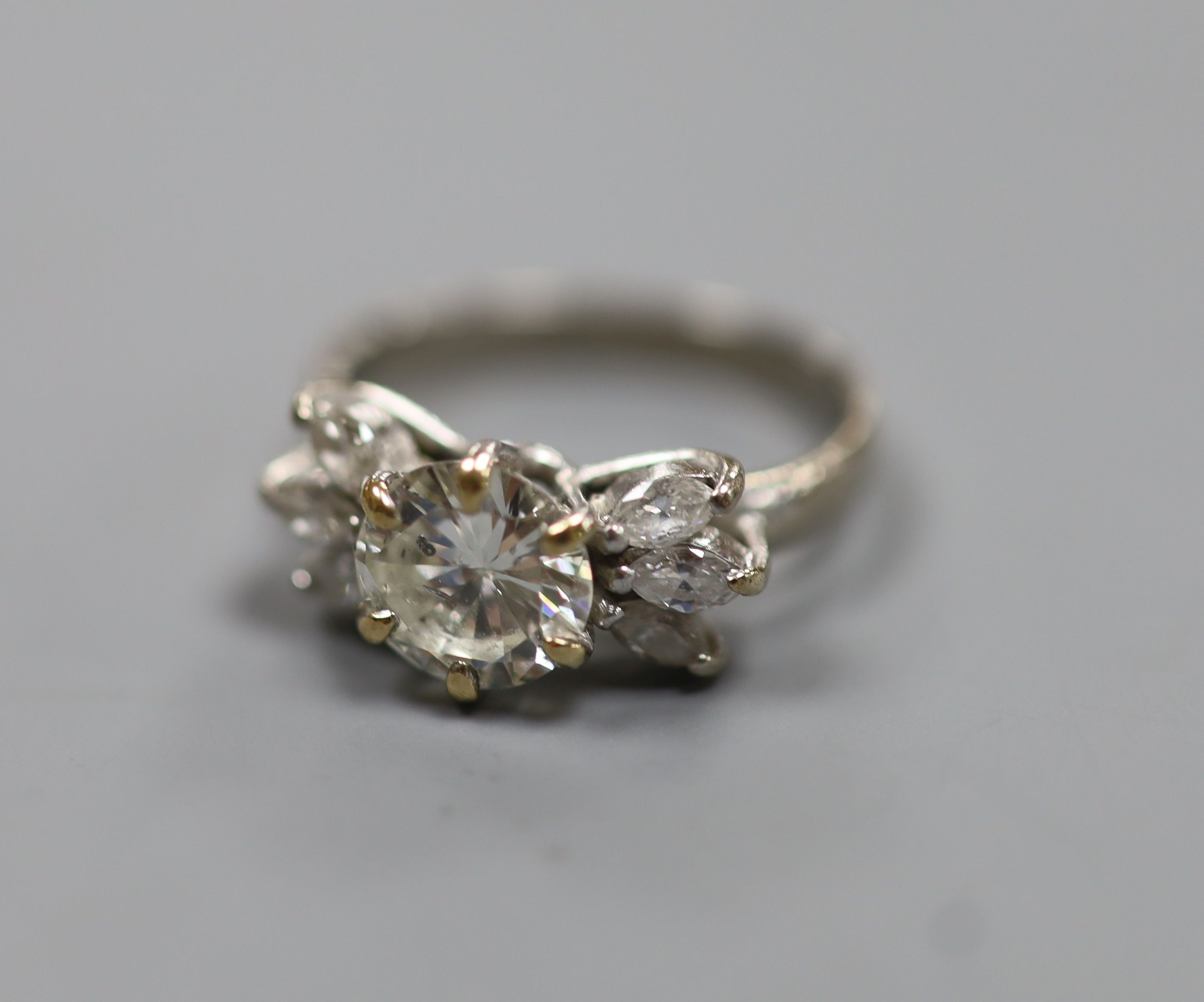 A white metal (stamped 18ct Plat) and single stone diamond ring, with six stone marquise cut diamond set shoulders, size K